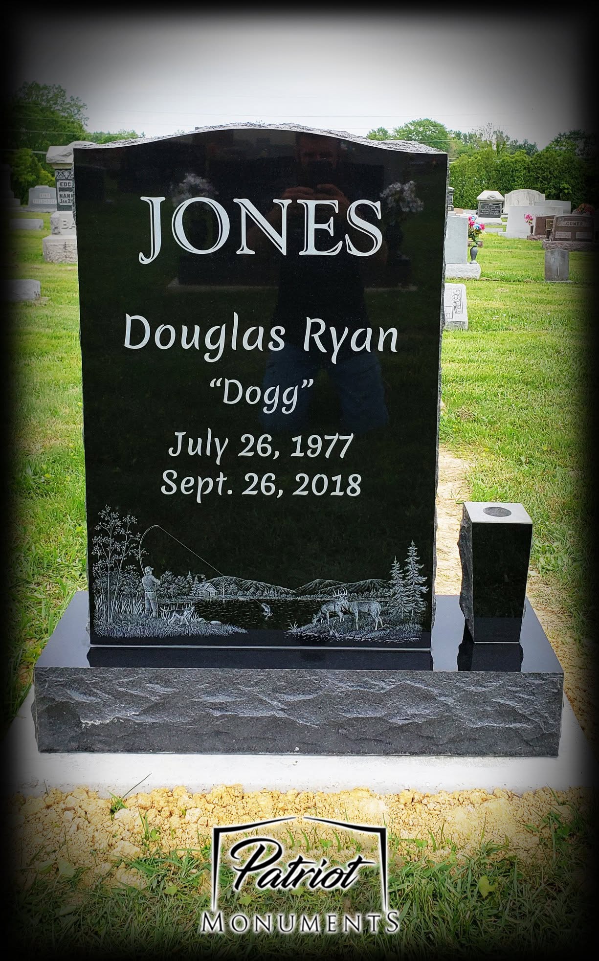 Jones Douglas Ryan black granite monument with fishing and deer scene engraving